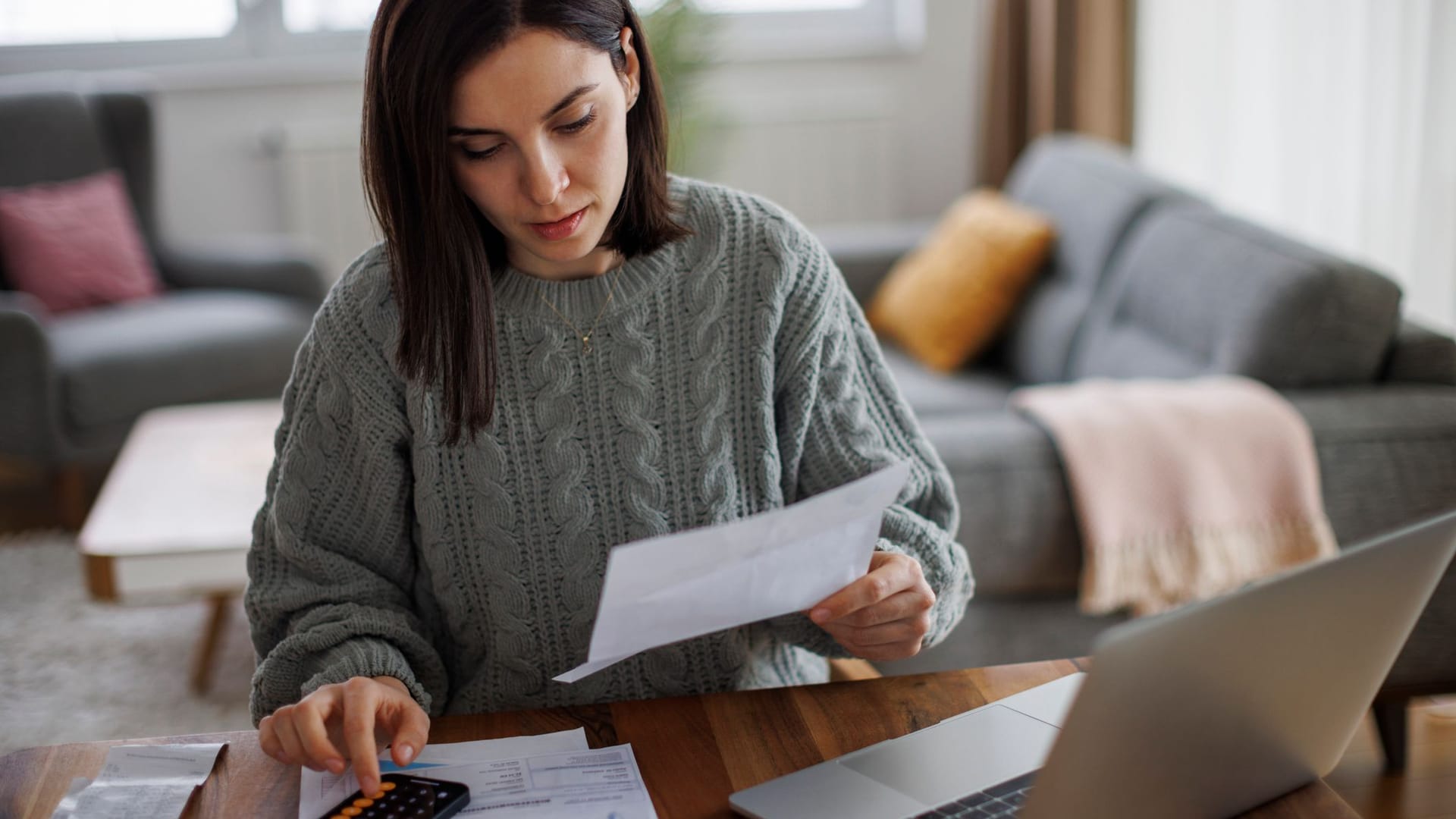 Eine Frau prüft eine Rechnung (Symbolbild): Jede dritte Person in Deutschland macht sich ernsthaft Gedanken um ihre Finanzen.