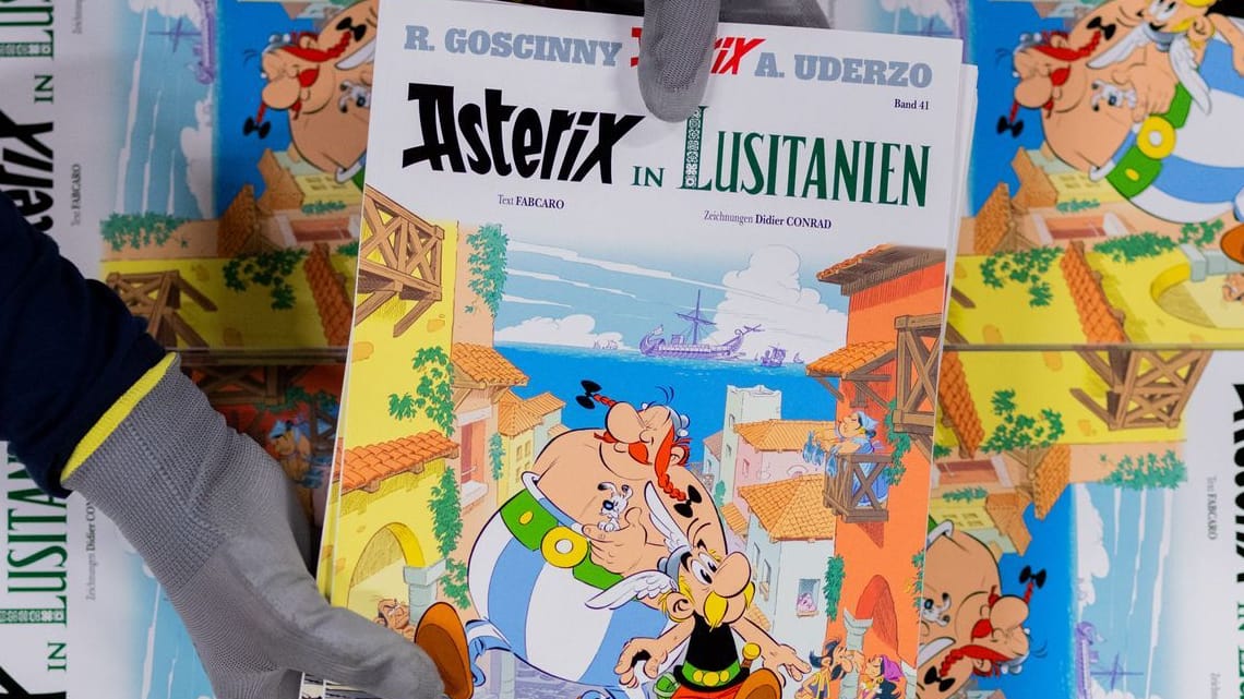 Editionen des neuen Asterix-Bandes Nummer 41 werden in einer Logistikhalle zusammengestellt und in Displays für den Handel verpackt. Editionen des neuen Asterix-Bandes Nummer 41 werden in einer Logistikhalle zusammengestellt und in Displays für den Handel verpackt.
