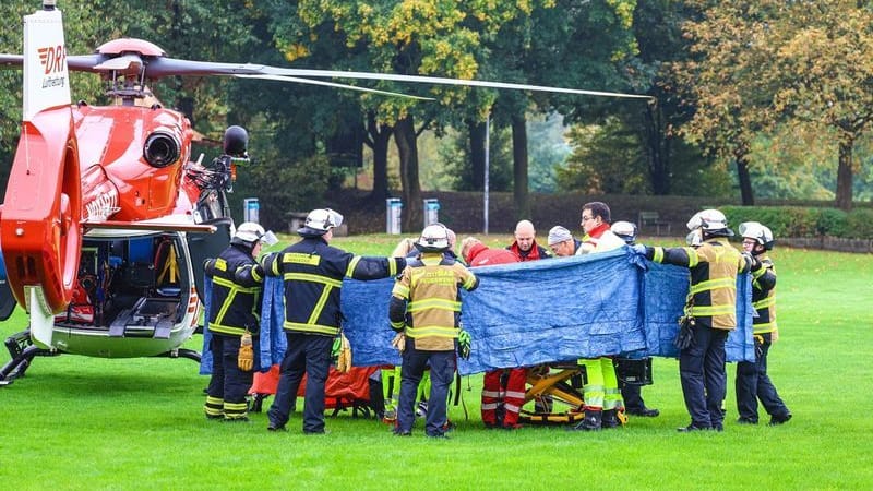 Einsatzkräfte stehen neben einem Rettungshubschrauber. Die neu gewählte Bürgermeisterin von Herdecke, Iris Stalzer (SPD), ist lebensgefährlich verletzt worden. Einsatzkräfte stehen neben einem Rettungshubschrauber. Die neu gewählte Bürgermeisterin von Herdecke, Iris Stalzer (SPD), ist lebensgefährlich verletzt worden.
