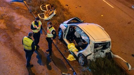 Polizisten stehen an der Unfallstelle: Mehrere Fahrzeuge stießen zusammen, eine Frau wurde eingklemmt.