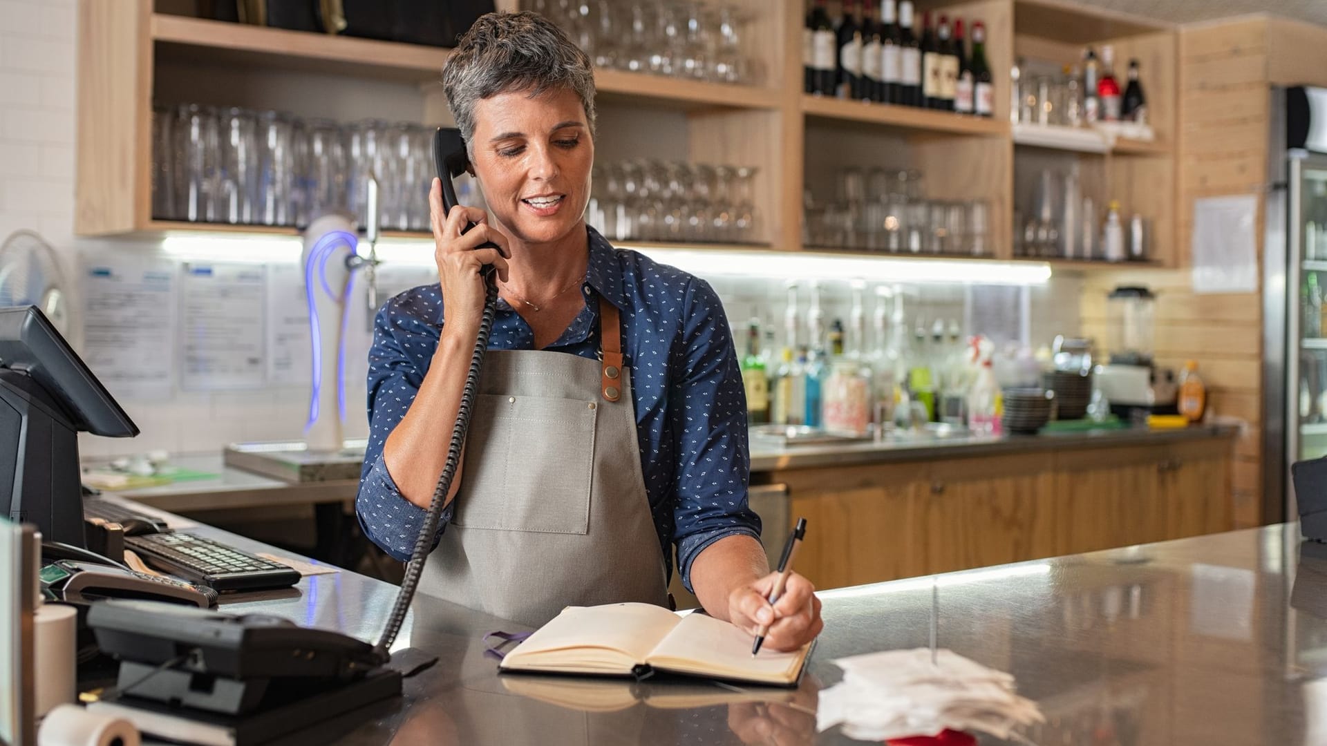 Frau arbeitet in einem Café und nimmt Bestellungen auf Frau arbeitet in einem Café und nimmt Bestellungen auf