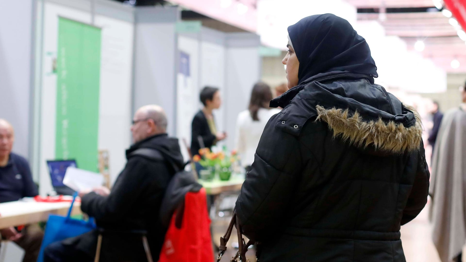 Eine Frau mit Kopftuch auf einer Jobbörse (Symbolbild): Auch die Kinder von Geflüchteten sind überdurchschnittlich oft von Armut betroffen. Eine Frau mit Kopftuch auf einer Jobbörse (Symbolbild): Auch die Kinder von Geflüchteten sind überdurchschnittlich oft von Armut betroffen.