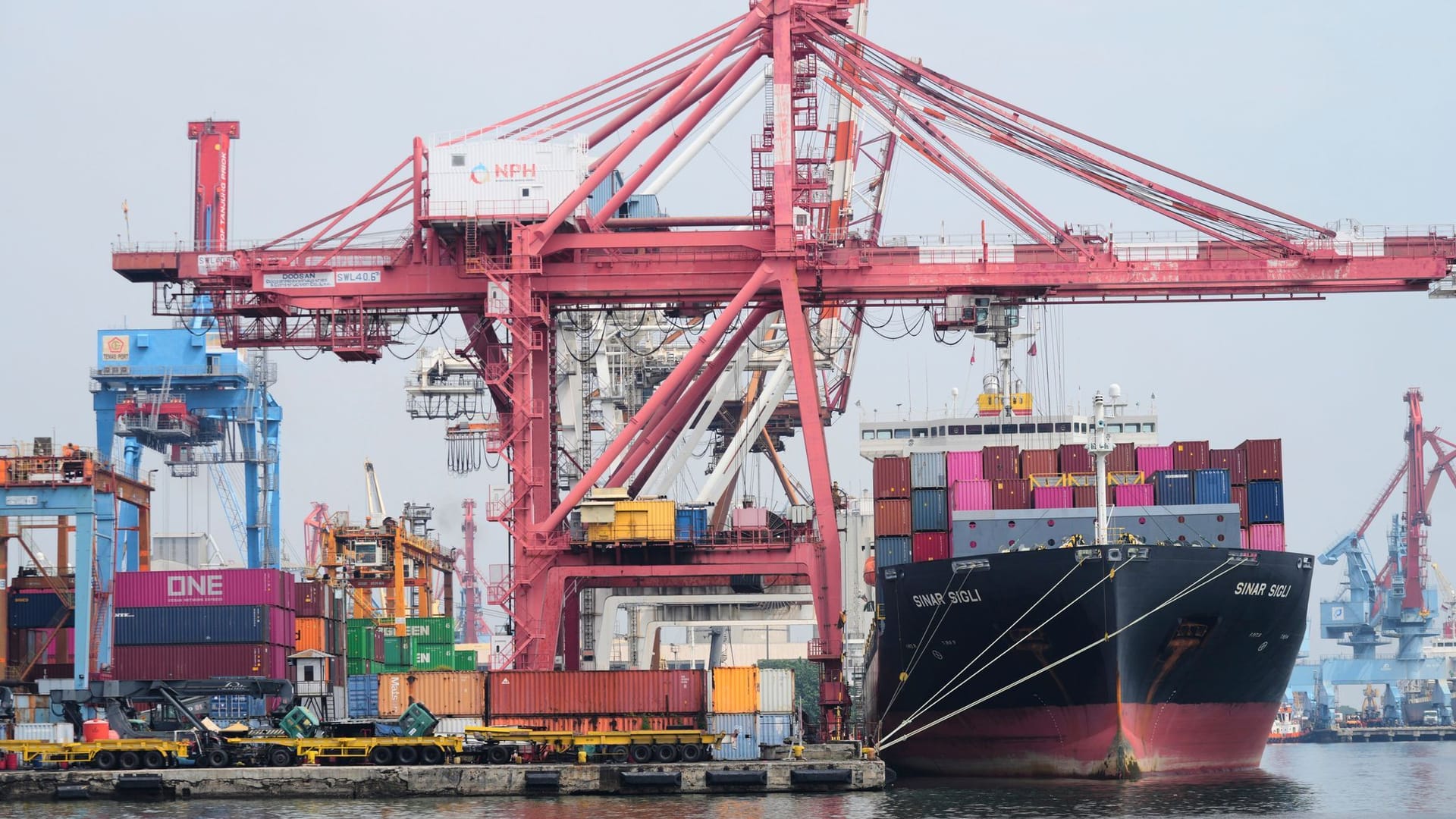 Indonesien, Jakarta: Kräne verladen Schiffscontainer auf ein Frachtschiff. Indonesien, Jakarta: Kräne verladen Schiffscontainer auf ein Frachtschiff.