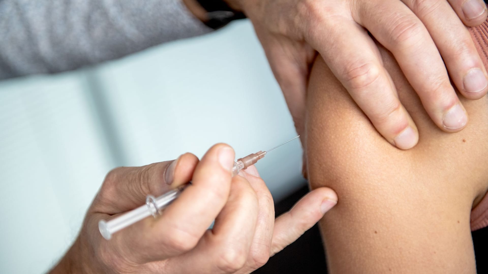 Ein Arzt impft eine Frau Ein Arzt impft eine Frau