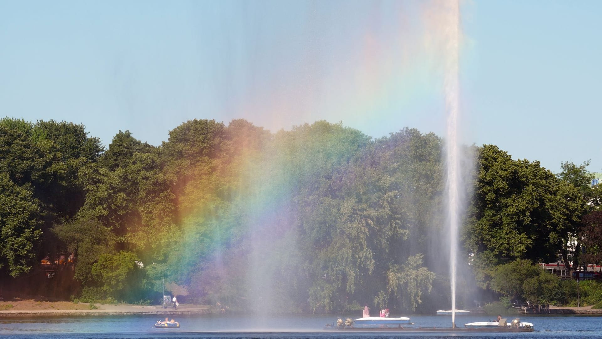 Hamburg: Tretboote und Ruderboote fahren durch die Gischt der Alsterfontäne auf der Binnenalster in der Innenstadt. Hamburg: Tretboote und Ruderboote fahren durch die Gischt der Alsterfontäne auf der Binnenalster in der Innenstadt.
