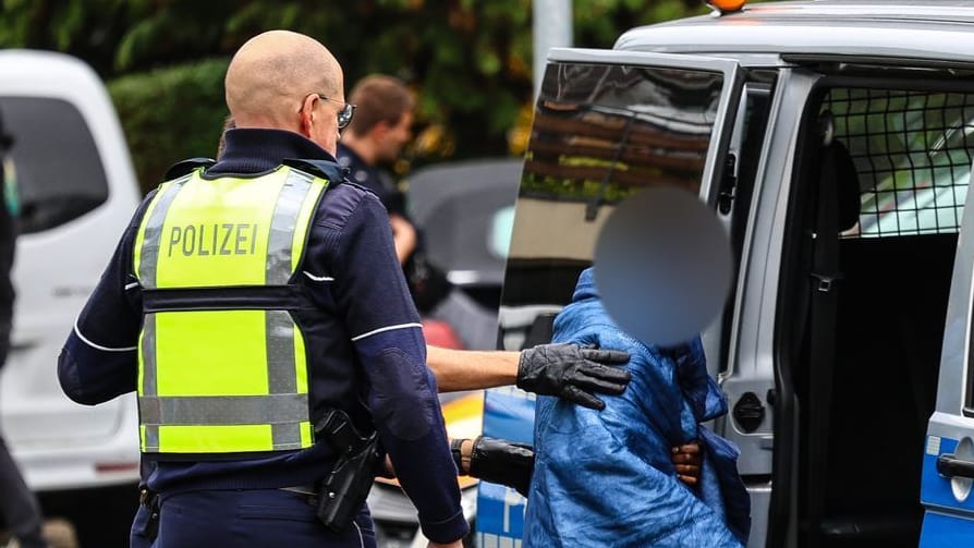 Herdecke: Polizisten bringen einen Jugendlichen, mutmaßlich den Stiefsohn von Iris Stalzer, zu einem Polizeiauto. Herdecke: Polizisten bringen einen Jugendlichen, mutmaßlich den Stiefsohn von Iris Stalzer, zu einem Polizeiauto.
