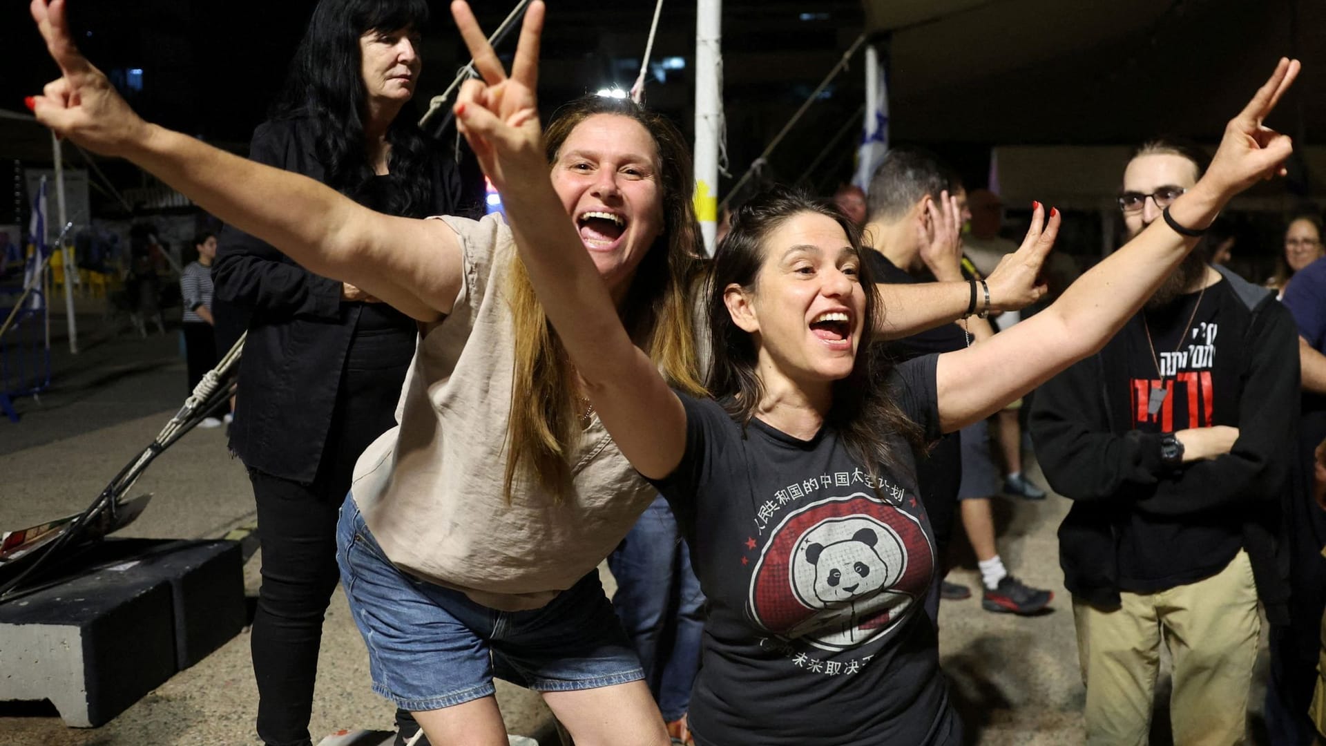 Menschen stehen in Tel Aviv auf dem sogenannten "Platz der Geiseln" und feiern. Menschen stehen in Tel Aviv auf dem sogenannten "Platz der Geiseln" und feiern.