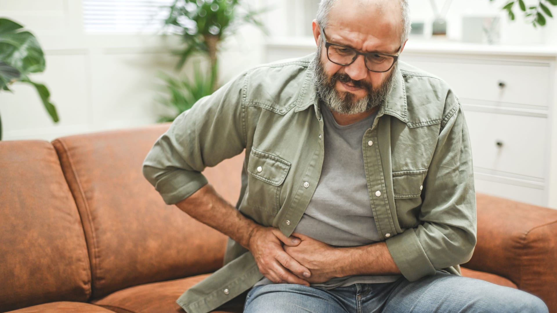 Ein Mann hält sich den rechten Unterbauch