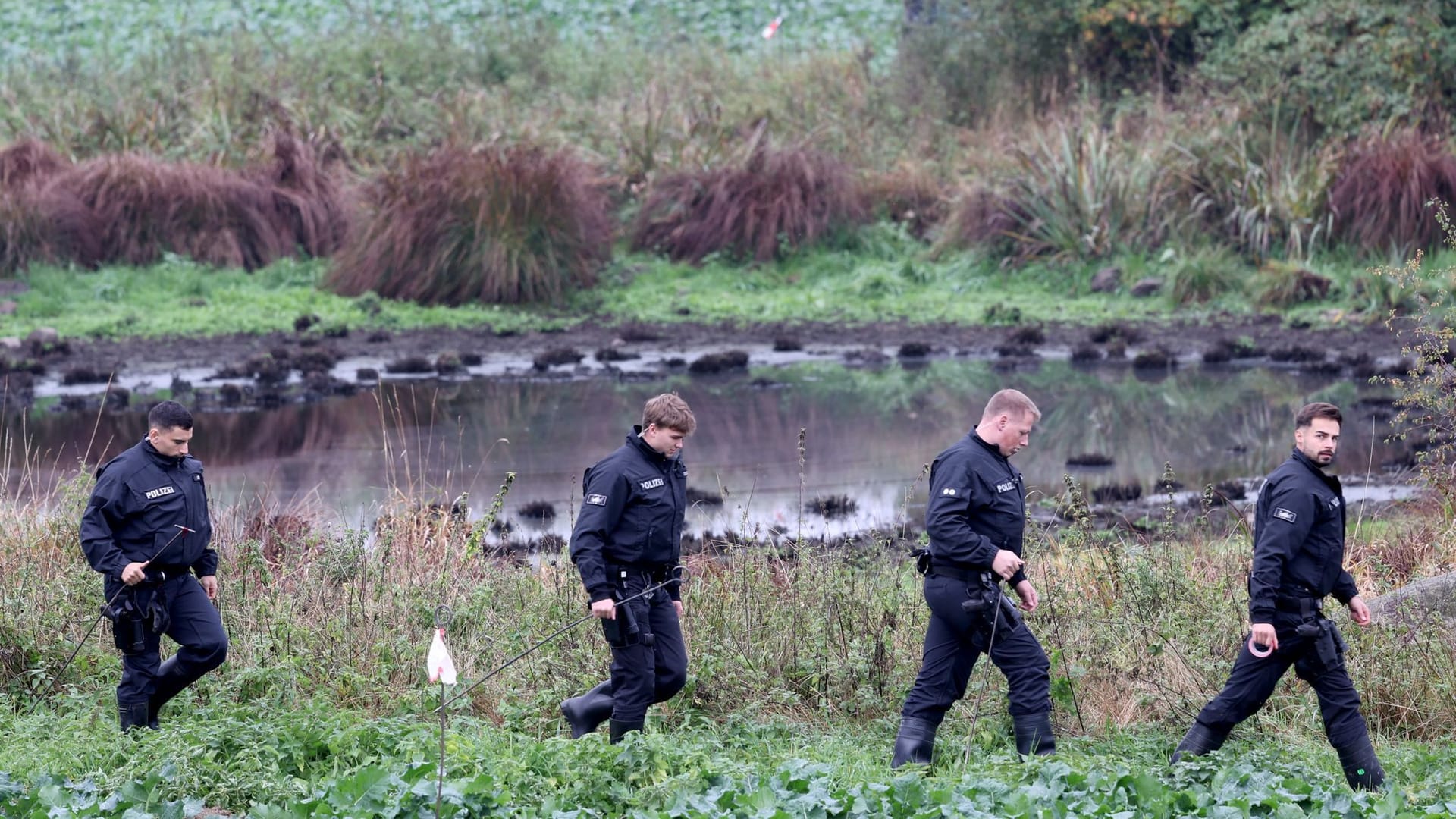 Klein Upahl am Mittwoch: Polizisten durchkämmen das Areal im weiten Umkreis vom Fundort.