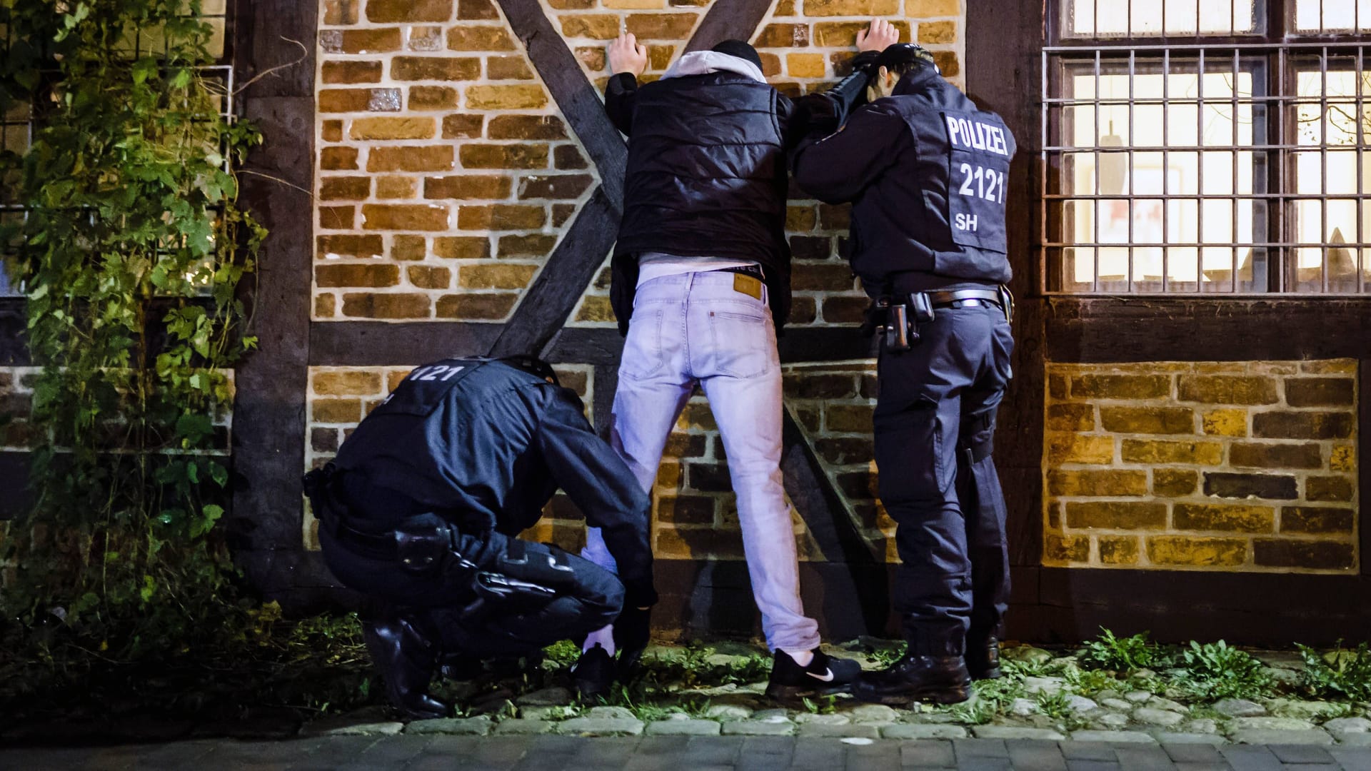 Polizisten durchsuchen einen Mann (Symbolbild): In Köpenick randalierten in der Nacht zu Sonntag rund 30 Menschen nach einer Party.