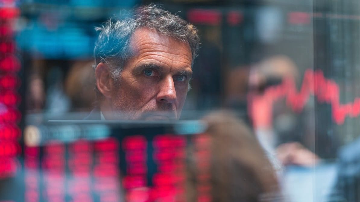 Analyst starrt auf den Bildschirm mit fallenden Börsenkursen