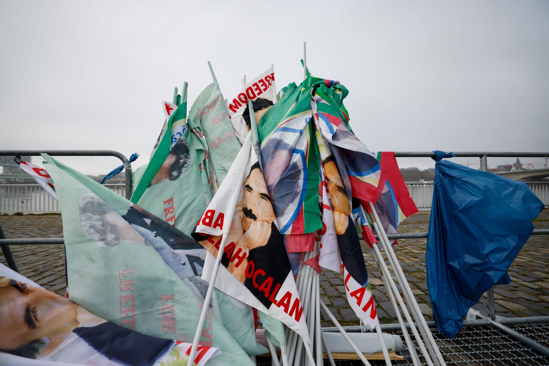 Fahnen stehen vor der kurdischen Großdemonstration zusammengerollt am Rand. In Köln demonstrierten heute Tausende Menschen.