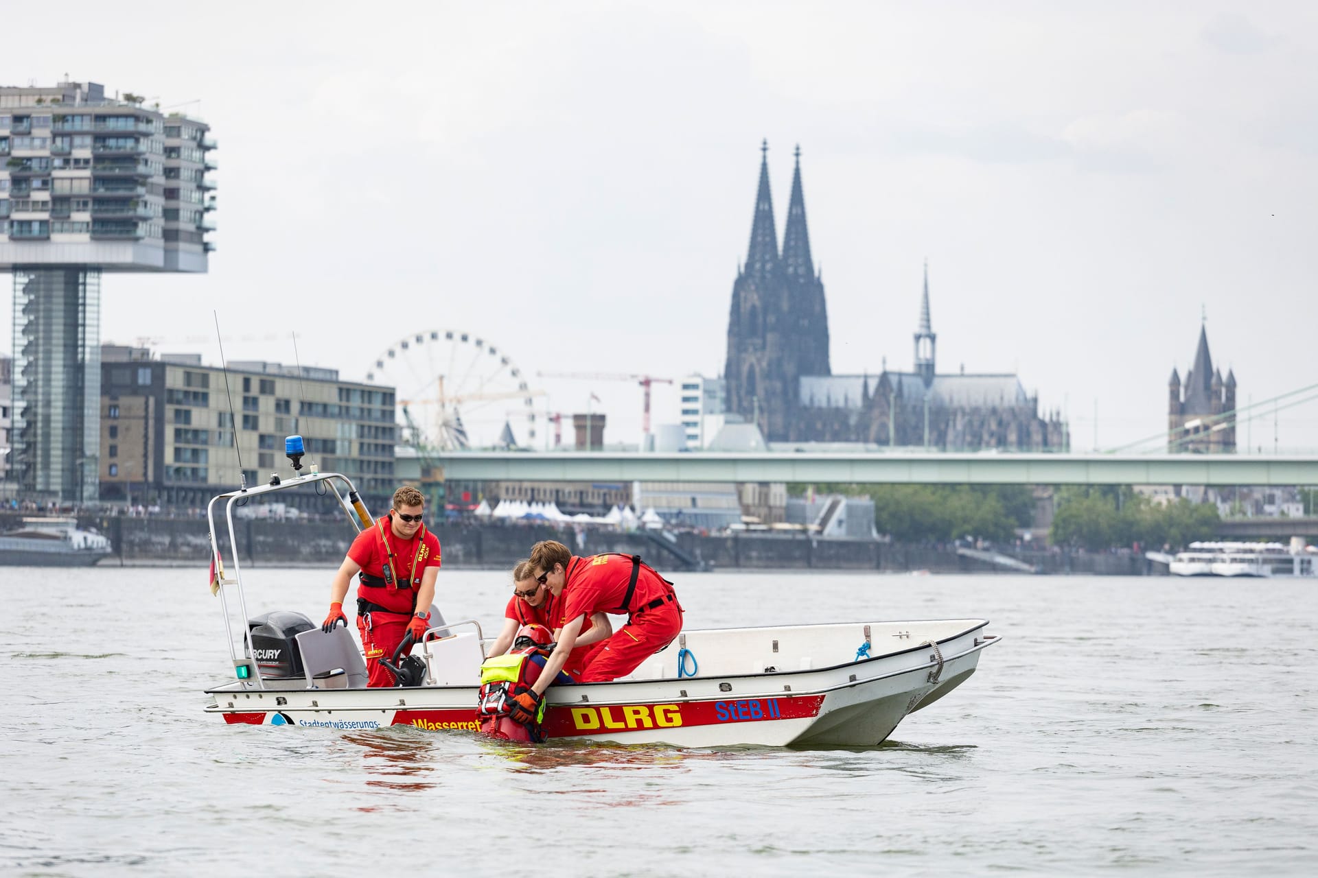 Im Schatten des Doms: Maximilian Jeserich, Katrin Schramke, Niklas Abele und Fenja Hesse (als Patientin) üben auf dem Rhein die Menschenrettung.