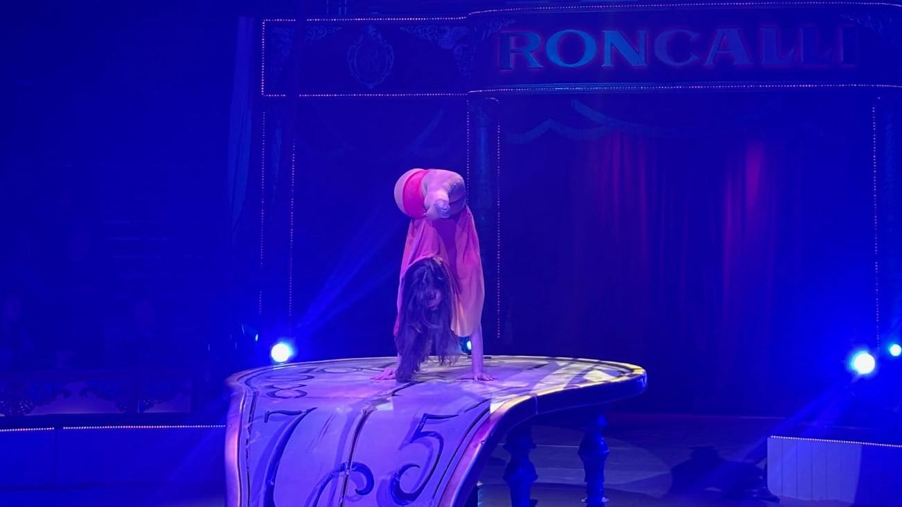 Auf einem Tisch, der aussieht wie eine Uhr, verbiegt die Zirkustochter sich in alle Richtungen.