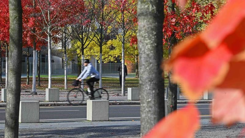 Ein Mann fährt vor dem Kanzleramt mit dem Fahrrad (Archivbild): Bei milden Temperaturen und einigen Wolken bleibt es in den kommenden Tagen trocken.