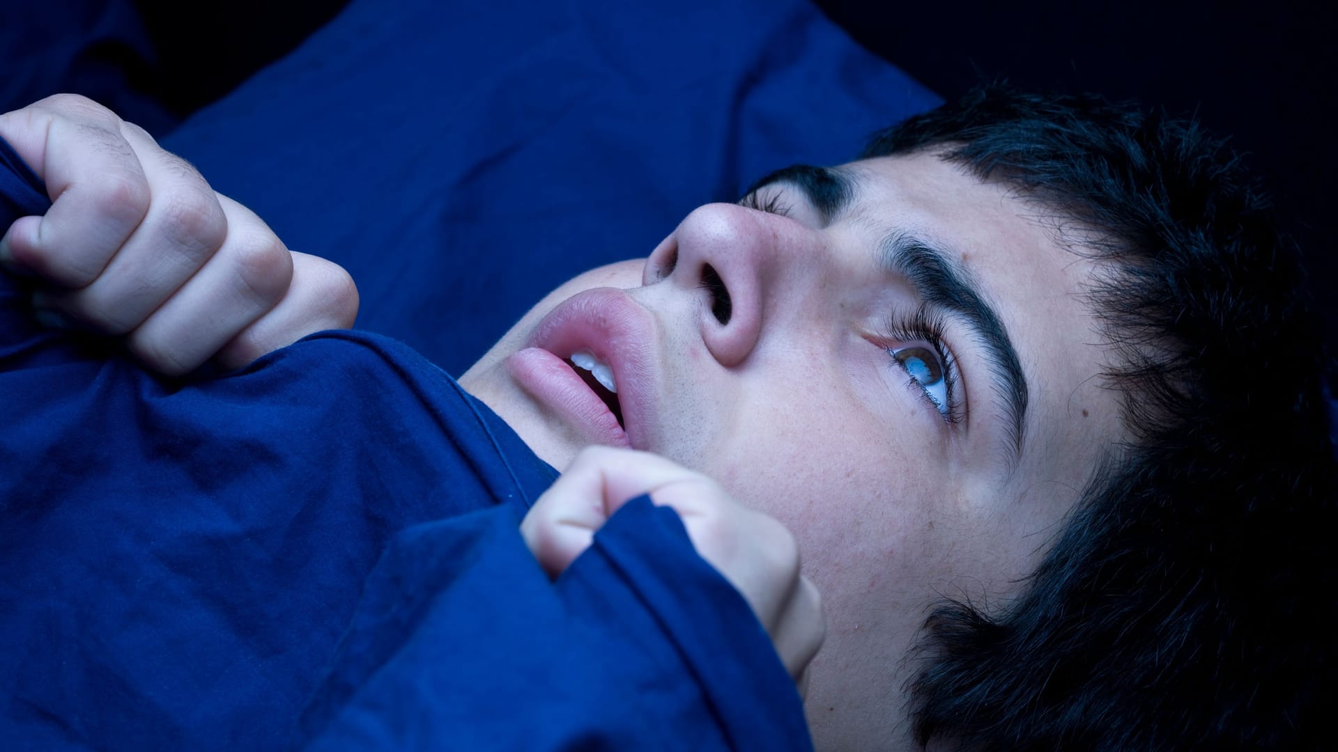 Eine erschrocken wirkende Frau im Bett Eine erschrocken wirkende Frau im Bett